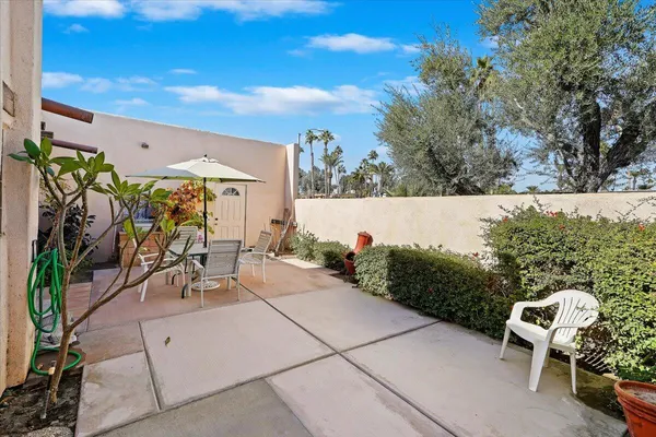 a view of a patio with table and chairs and potted plants