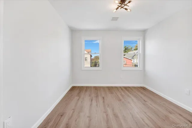 an empty room with a window and a ceiling fan