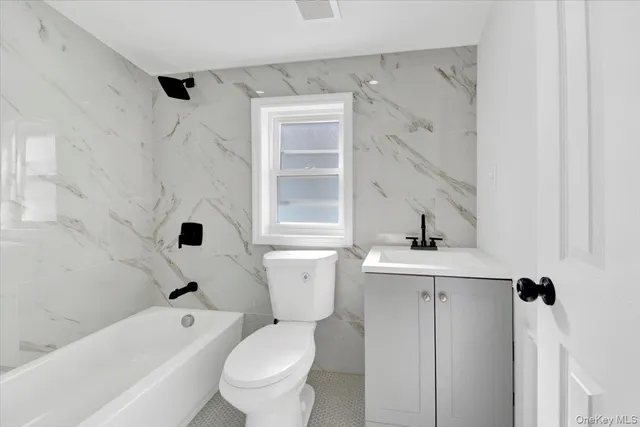 a white toilet sitting next to a bathroom sink and tub