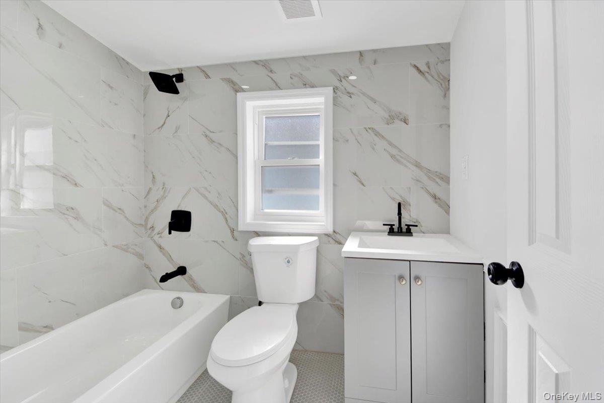 4626 Richardson Avenue, Unit 2 Bronx, NY 10470 - Photo 14 of 20 a white toilet sitting next to a bathroom sink and tub