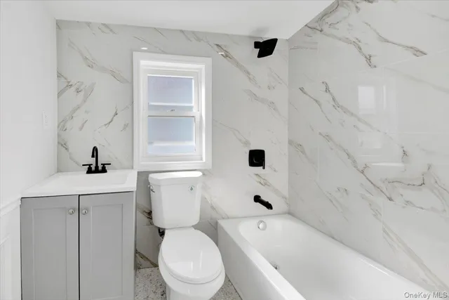 a bathroom with a toilet a sink and bathtub