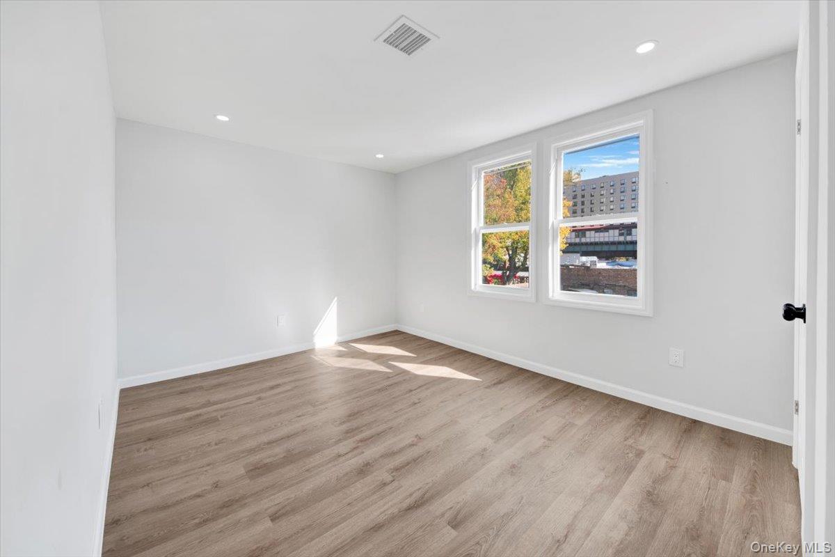 4626 Richardson Avenue, Unit 2 Bronx, NY 10470 - Photo 16 of 20 an empty room with wooden floor and windows