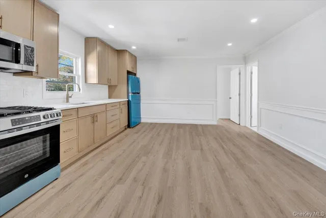 a view of kitchen with wooden floor electronic appliances and window