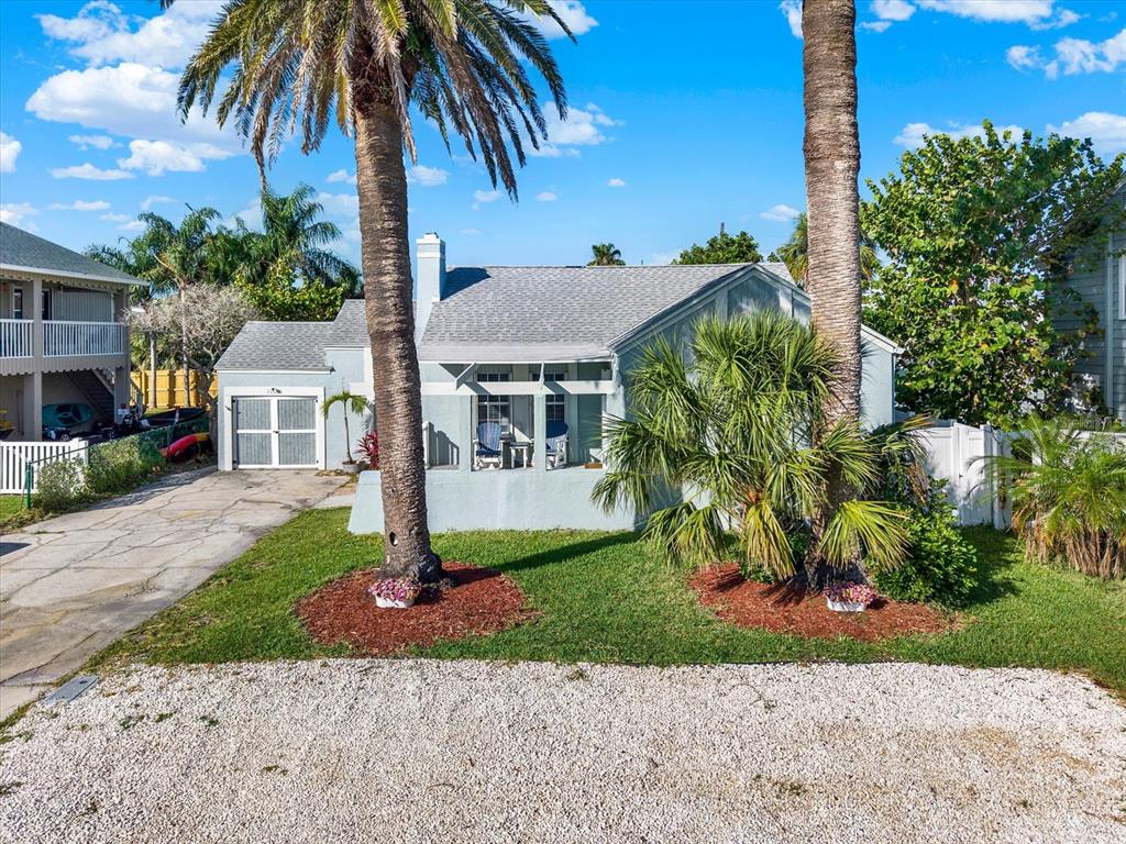 15656 1st Street East Redington Beach, FL 33708 - Photo 1 of 32 a front view of a house with a garden and tree