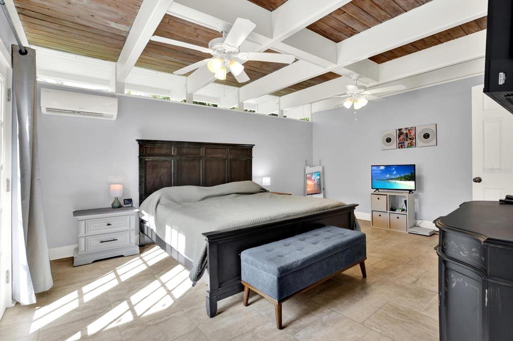 15656 1st Street East Redington Beach, FL 33708 - Photo 12 of 32 a bedroom with a bed a chandelier and closet