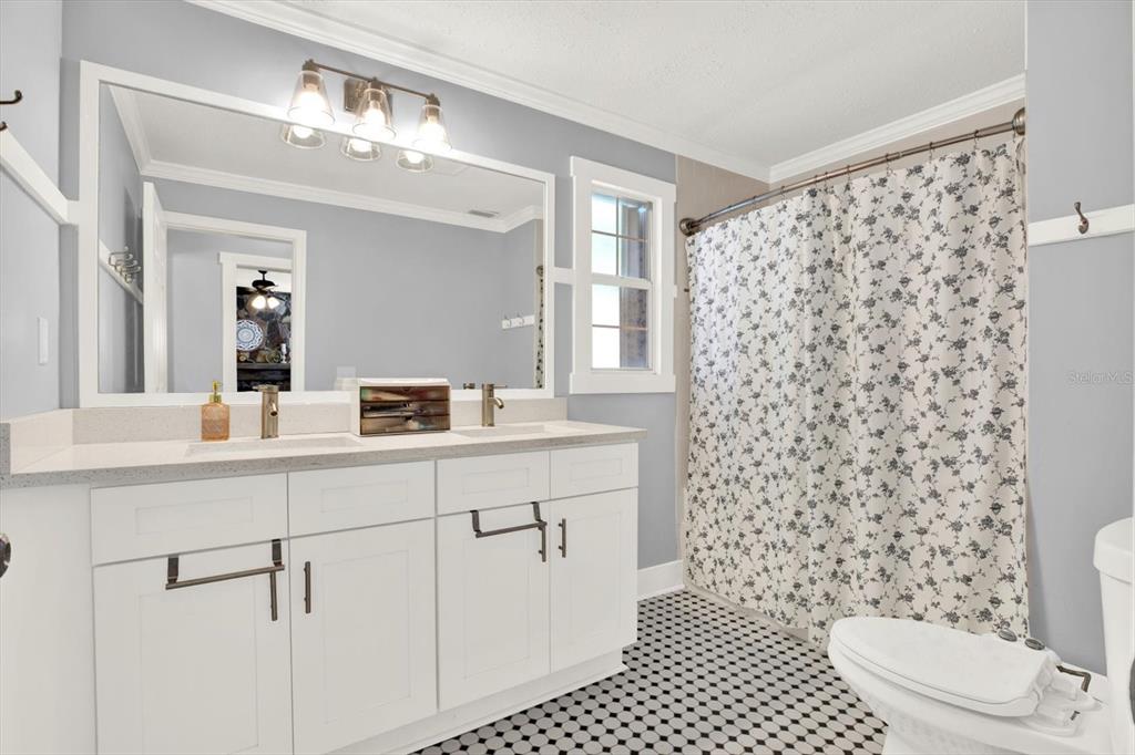 15656 1st Street East Redington Beach, FL 33708 - Photo 19 of 32 a bathroom with a double vanity sink mirror and toilet