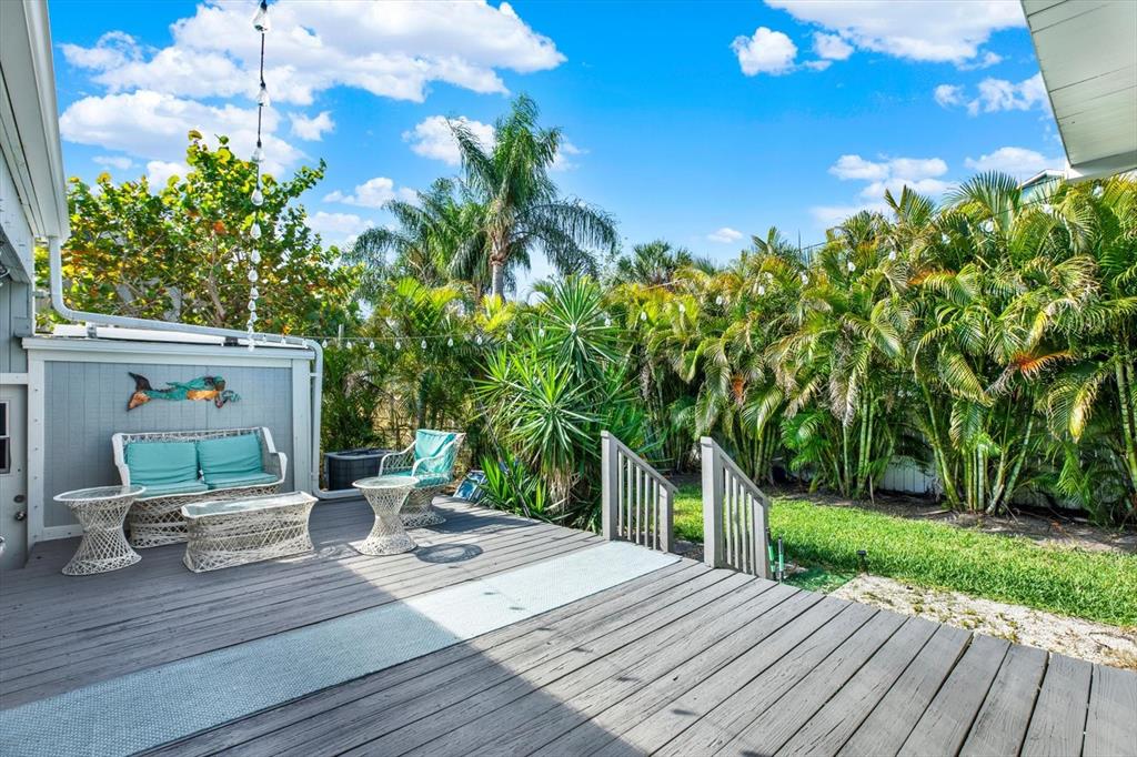 15656 1st Street East Redington Beach, FL 33708 - Photo 23 of 32 a patio with table and chairs and potted plants