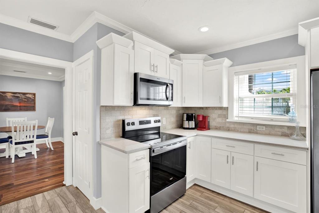 15656 1st Street East Redington Beach, FL 33708 - Photo 8 of 32 a kitchen with granite countertop white cabinets and white appliances