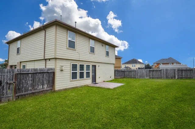 a view of a house with a yard and a wooden fence