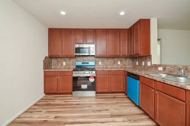 a kitchen with stainless steel appliances granite countertop a stove a sink and a refrigerator