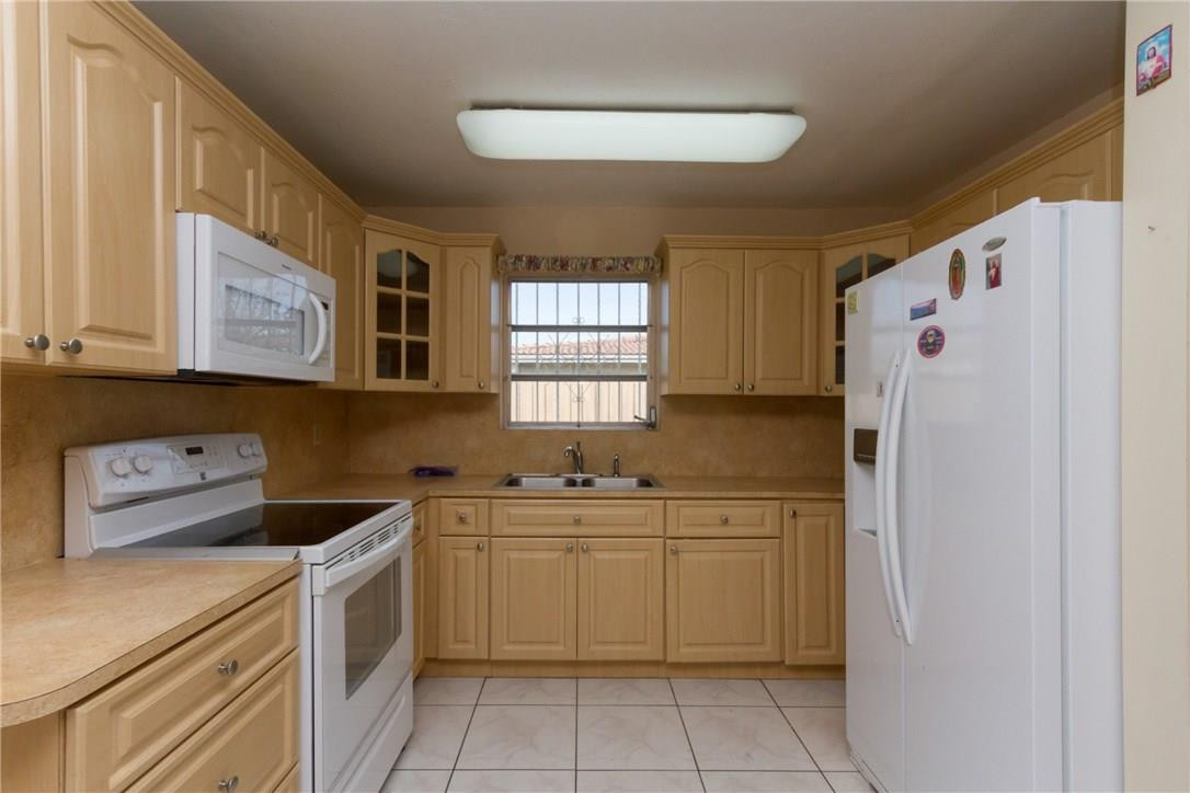 3300 Southwest 94th Court Miami, FL 33165 - Photo 15 of 18 a kitchen with a sink a refrigerator and cabinets