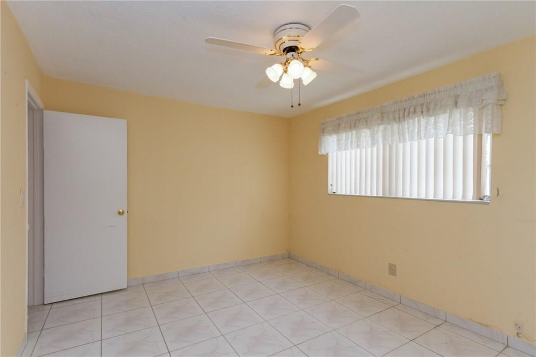 3300 Southwest 94th Court Miami, FL 33165 - Photo 5 of 18 an empty room with windows and chandelier fan