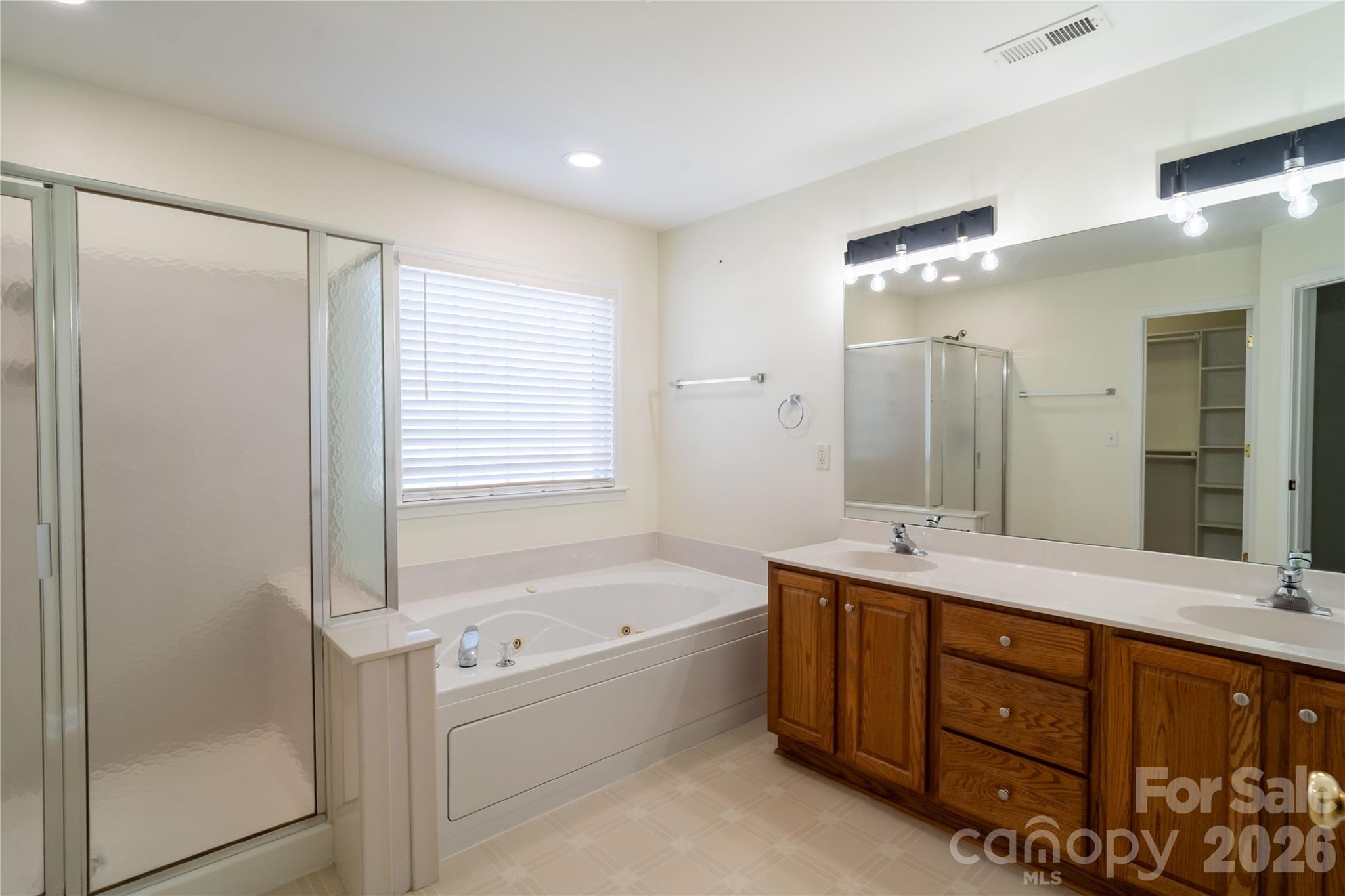 16905 Laureate Road, Unit 16 Huntersville, NC 28078 - Photo 29 of 38 a bathroom with a tub a sink double vanity and a mirror