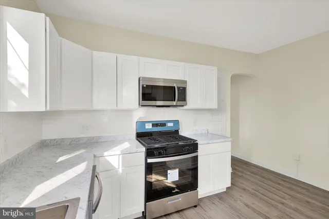 a kitchen with granite countertop a stove and a microwave