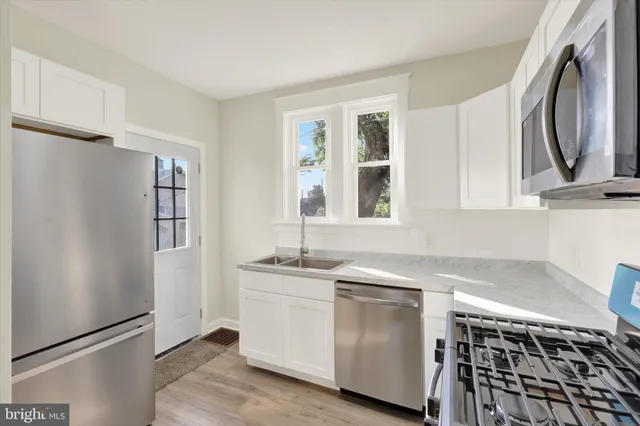 a kitchen with stainless steel appliances a stove a sink and a refrigerator