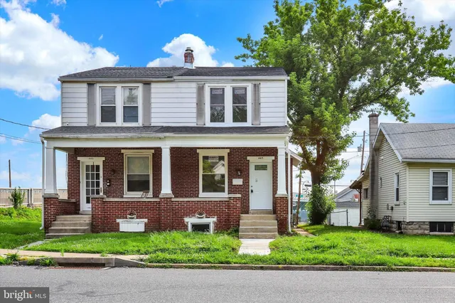 a front view of a house with a garden and plants
