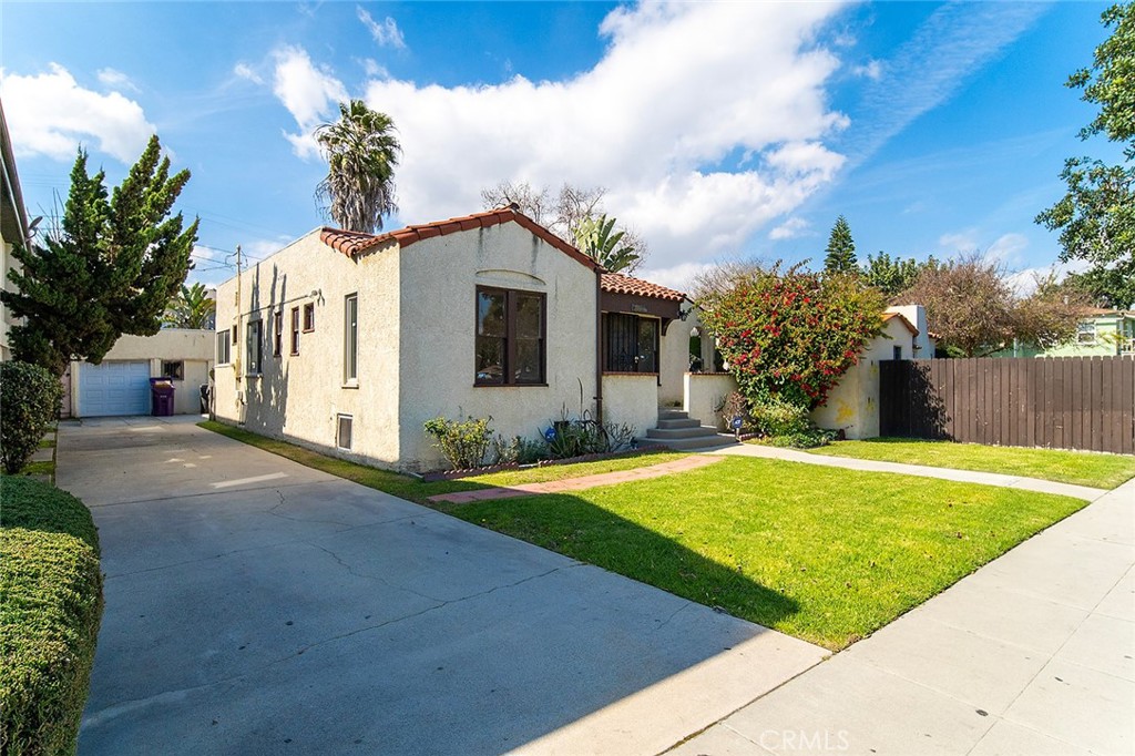 2285 Pine Avenue Long Beach, CA 90806 - Photo 3 of 25 a front view of a house with a yard and garage