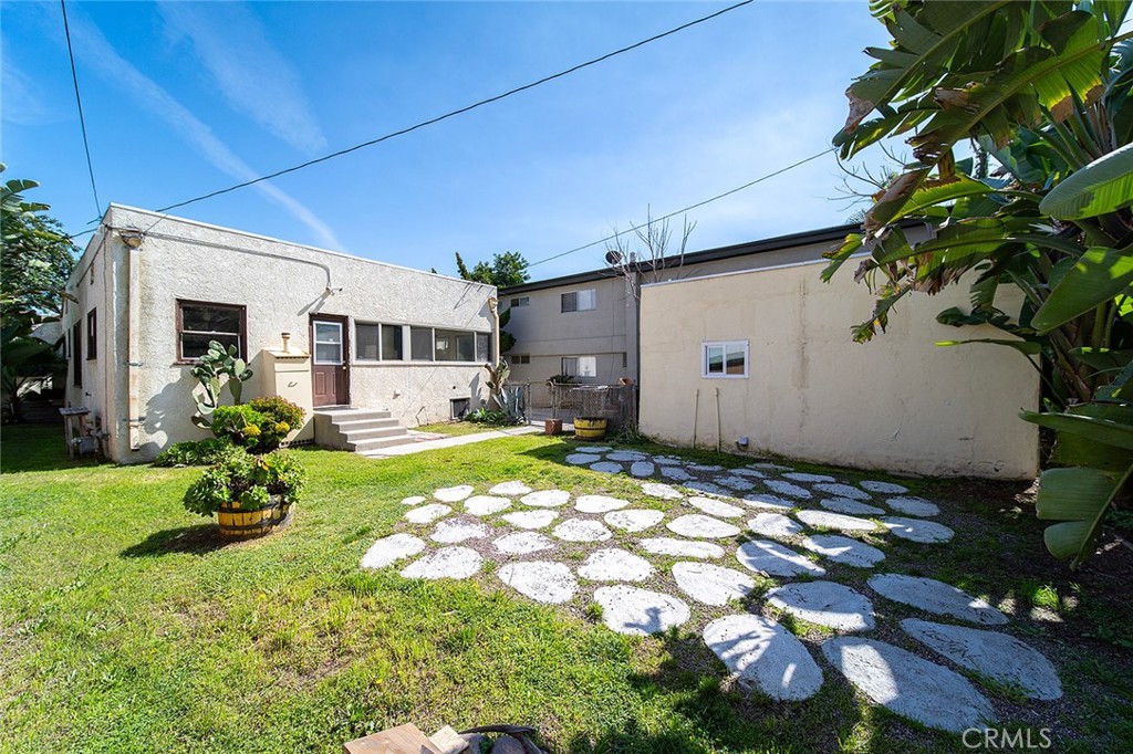 2285 Pine Avenue Long Beach, CA 90806 - Photo 6 of 25 a backyard of a house with table and chairs and potted plants