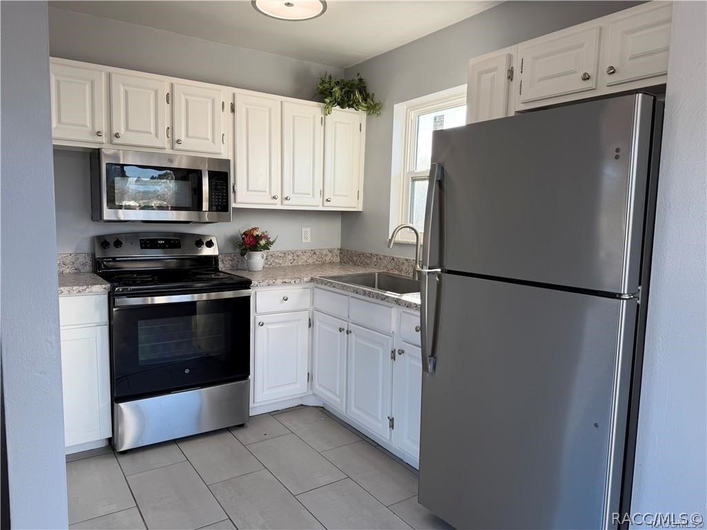 405 Copperfield Road Spring Hill, FL 34606 - Photo 8 of 25 a kitchen with cabinets and stainless steel appliances
