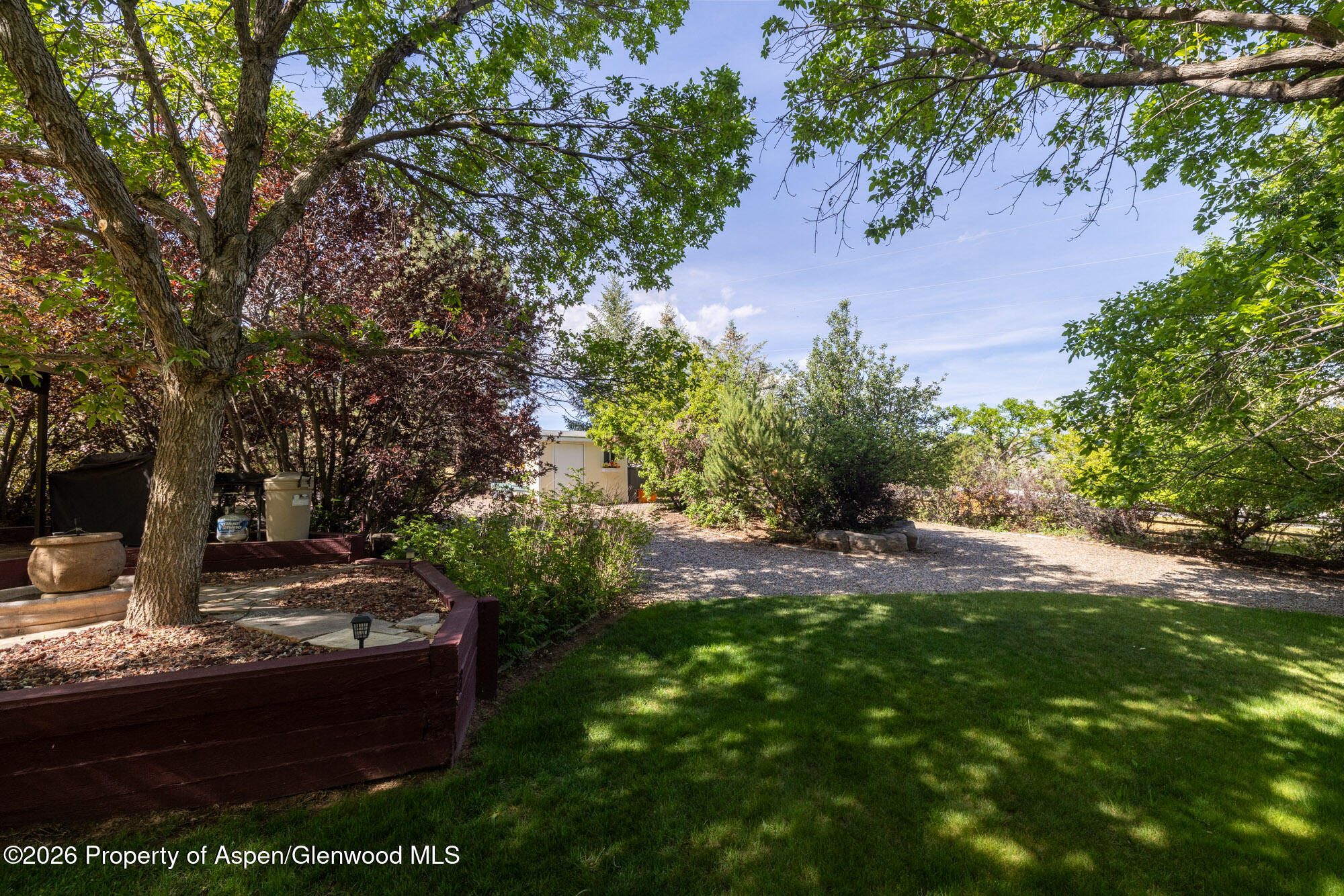 1335 Firethorn Drive Rifle, CO 81650 - Photo 22 of 30 a view of a yard with plants and a bench