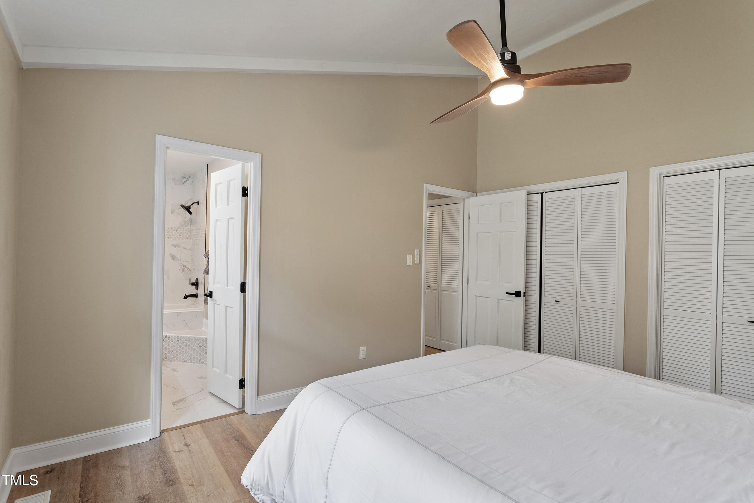 7825 Breckon Way Raleigh, NC 27615 - Photo 22 of 32 a bedroom with a bed and a chandelier