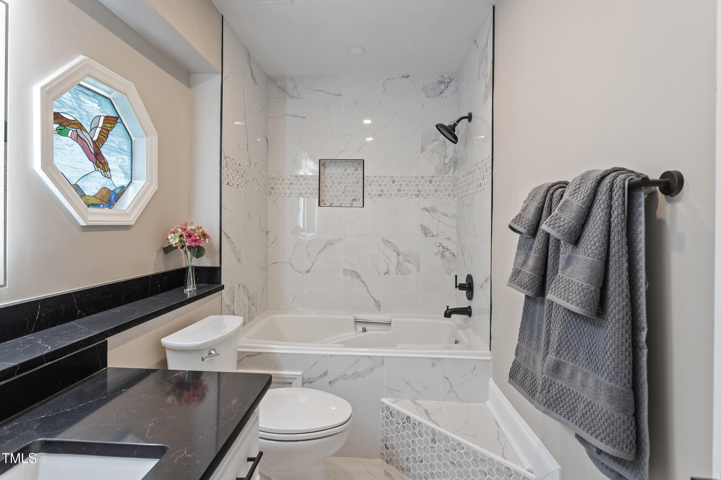 7825 Breckon Way Raleigh, NC 27615 - Photo 23 of 32 a bathroom with a granite countertop toilet a sink and bathtub