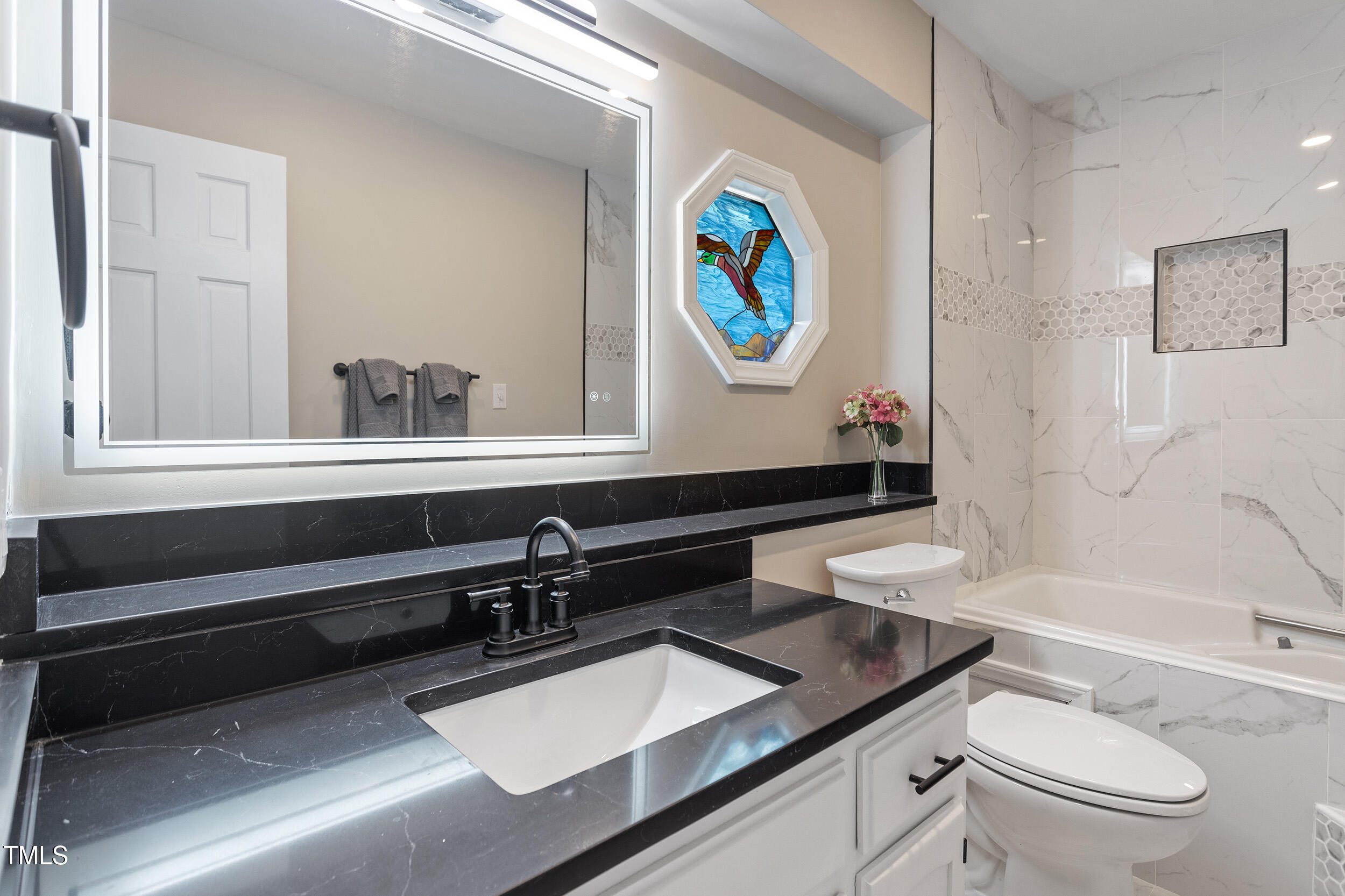 7825 Breckon Way Raleigh, NC 27615 - Photo 4 of 32 a bathroom with a sink a toilet and a bathtub