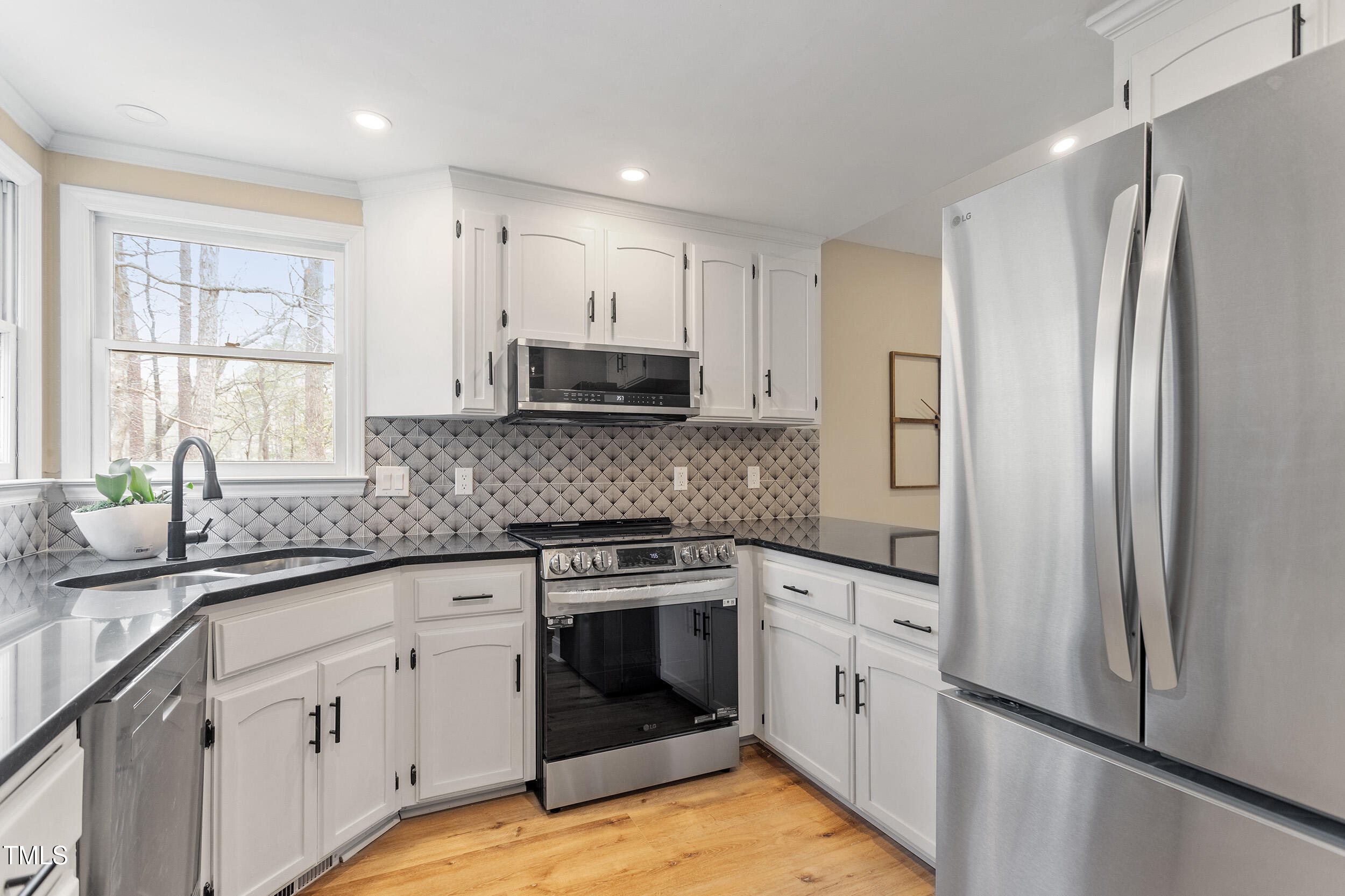 7825 Breckon Way Raleigh, NC 27615 - Photo 8 of 32 a kitchen with white cabinets stainless steel appliances and sink