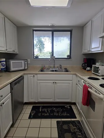 a kitchen with a sink a stove cabinets and appliances