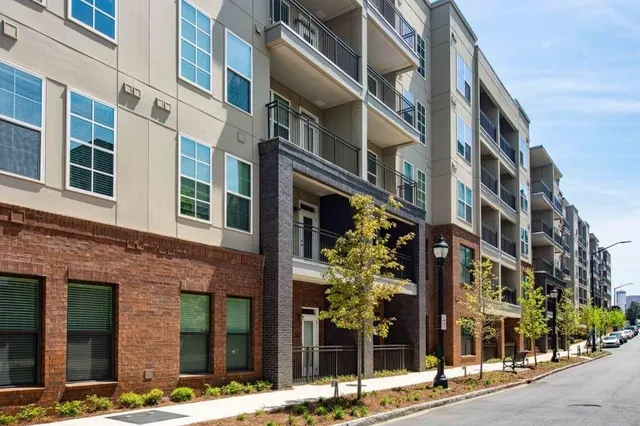 a kitchen with stainless steel appliances a refrigerator a stove a sink dishwasher and white cabinets with wooden floor