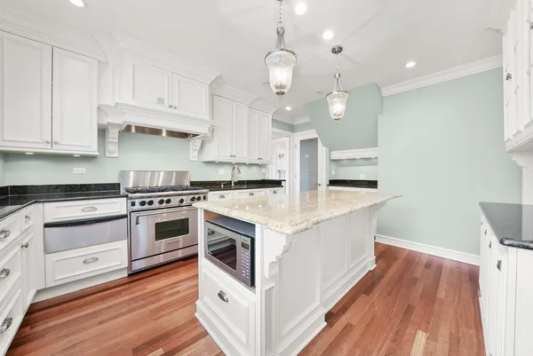 a kitchen with a stove and a wooden floor