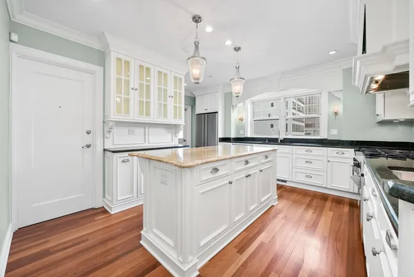 a large kitchen with granite countertop a large counter top space a sink stainless steel appliances and cabinets