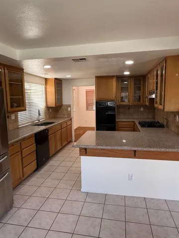 a large kitchen with a large counter top stainless steel appliances and cabinets