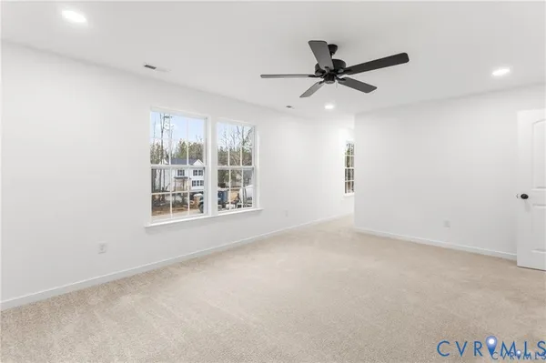 an empty room with windows and fan
