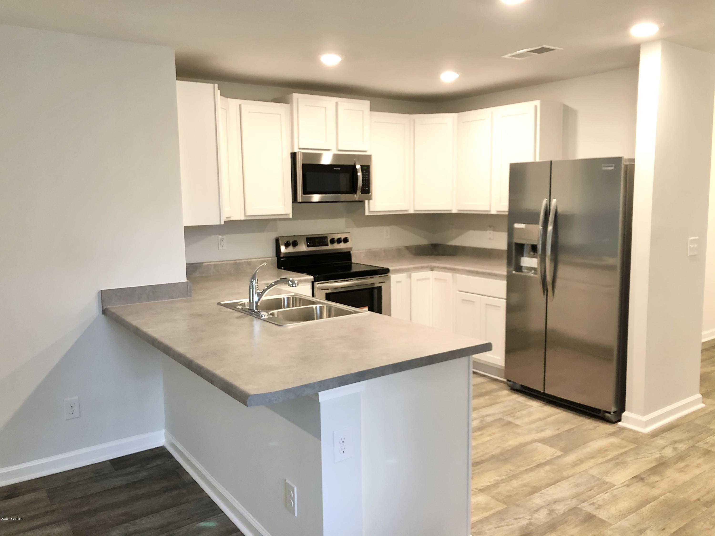 391 Ellis Road Southeast, Unit LOT #29 Bolivia, NC 28422 - Photo 1 of 29 The Allex's kitchen features white cabinets, stainless steel appliances, and a breakfast bar.