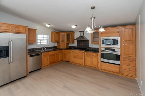 a kitchen with a sink stainless steel appliances and window