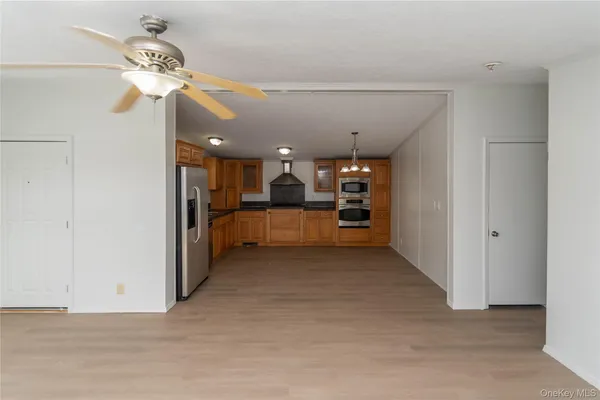 a view of a kitchen with a sink and a refrigerator