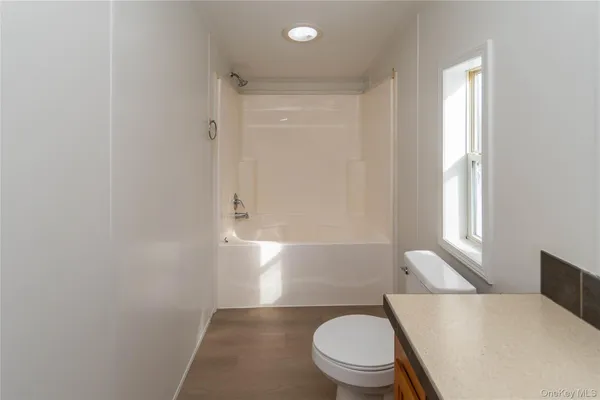 a white toilet sitting next to a window