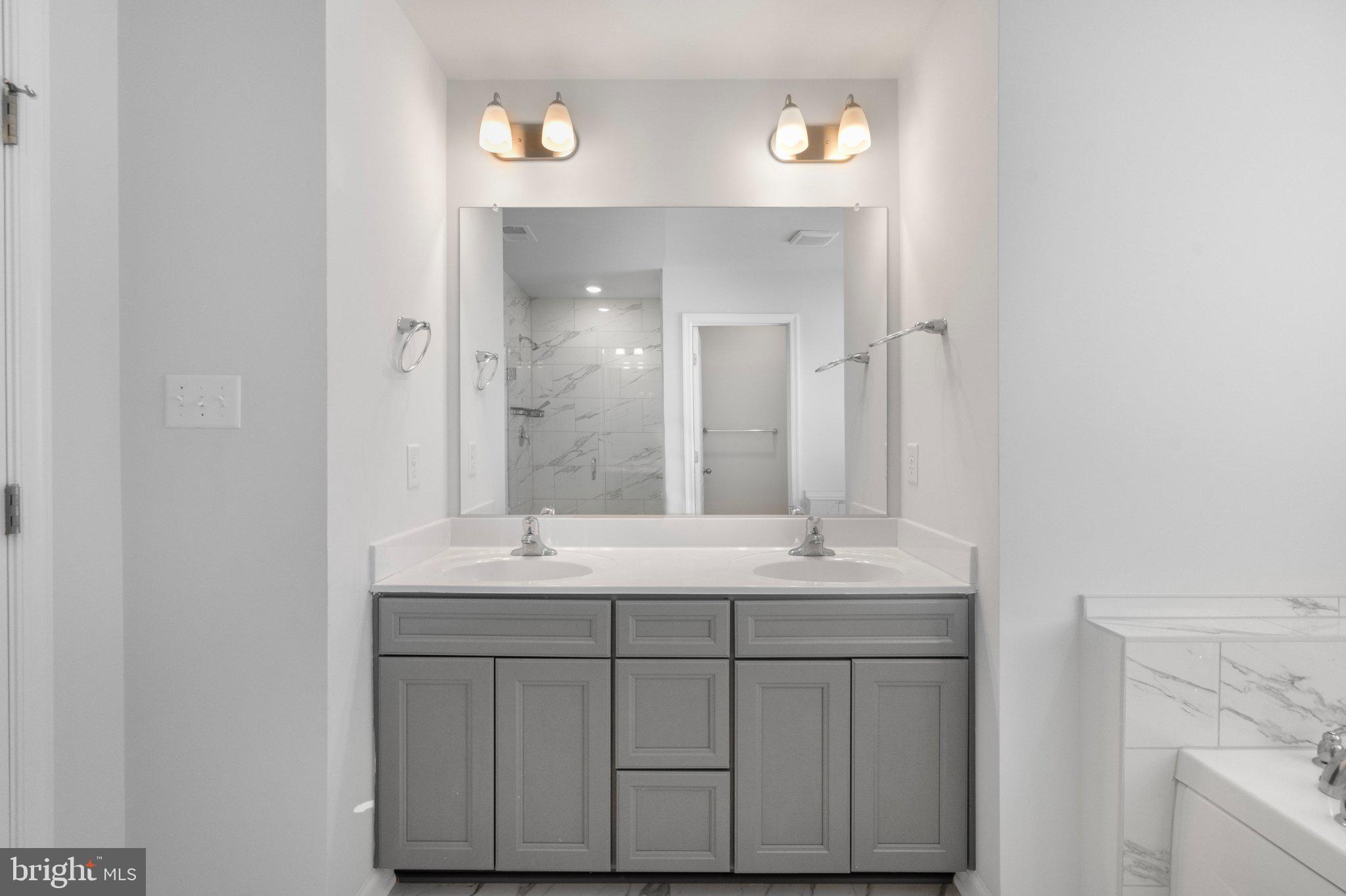 18950 Amesbury Road Hagerstown, MD 21742 - Photo 20 of 35 Sleek modern bathroom with dual sinks.
