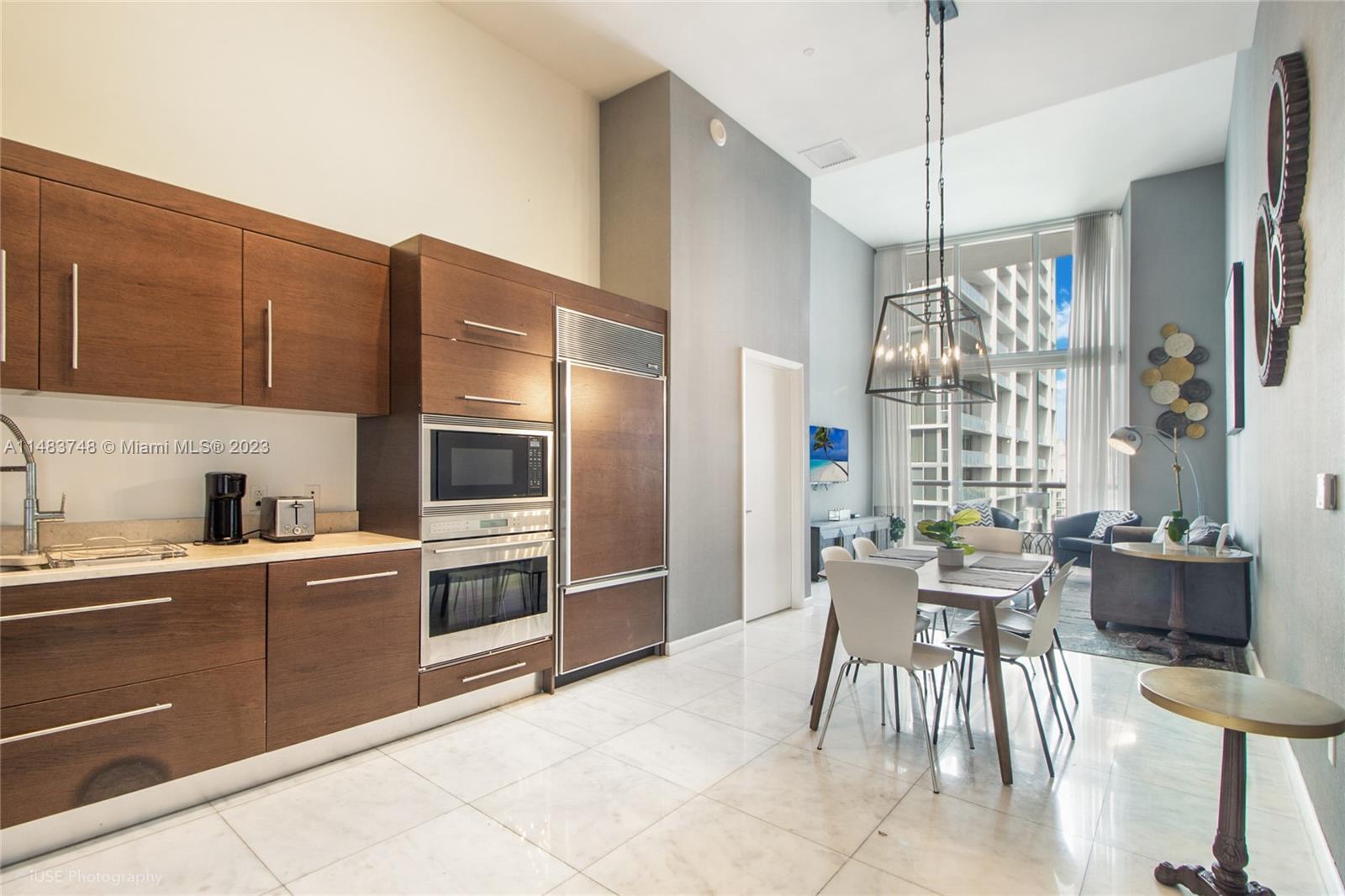 Brickell Miami, FL 33131 - Photo 2 of 10 a kitchen with a table chairs refrigerator and cabinets