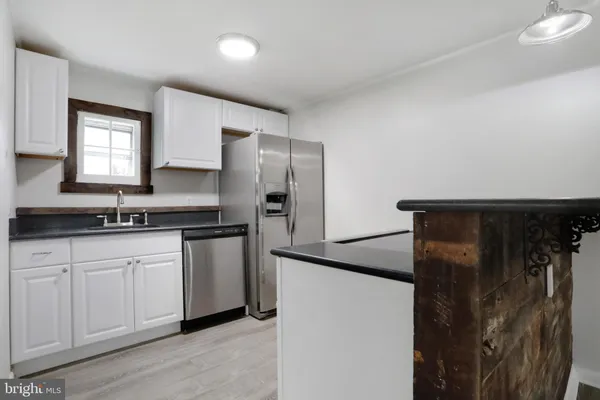 a kitchen with stainless steel appliances granite countertop a refrigerator and a sink