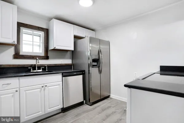 a kitchen with granite countertop white cabinets and a stainless steel appliances