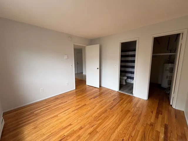 a view of a bedroom with wooden floor and closet