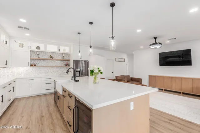 a kitchen with a stove a sink and a refrigerator with wooden floor
