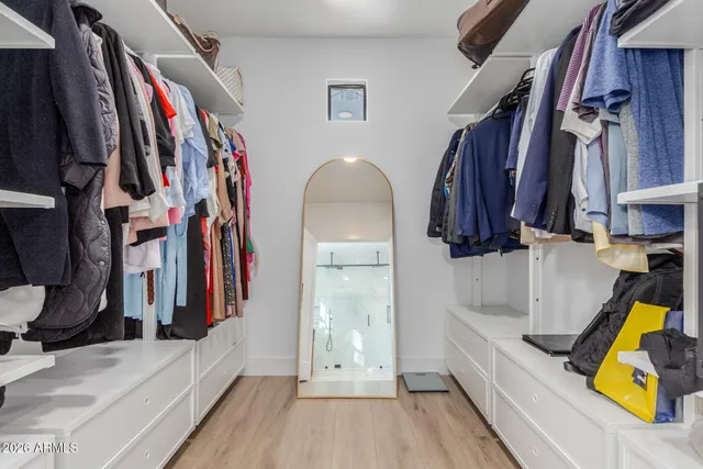a view of walk in closet with clothes and shoes