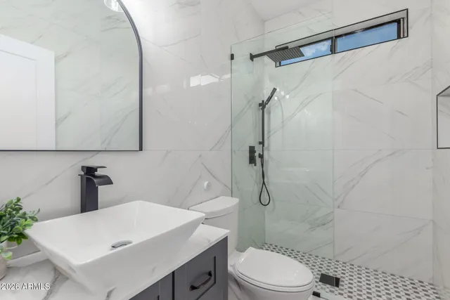 a bathroom with a sink a toilet and shower