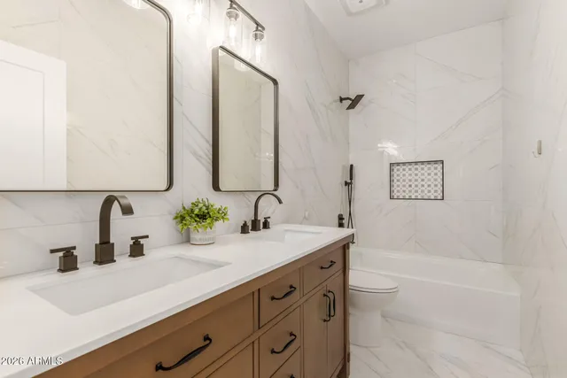 a bathroom with a double vanity sink mirror double and bathtub