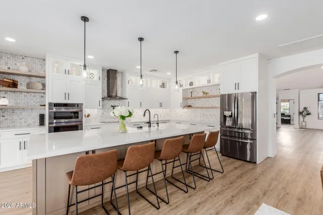 a kitchen with stainless steel appliances kitchen island granite countertop a kitchen island and a refrigerator