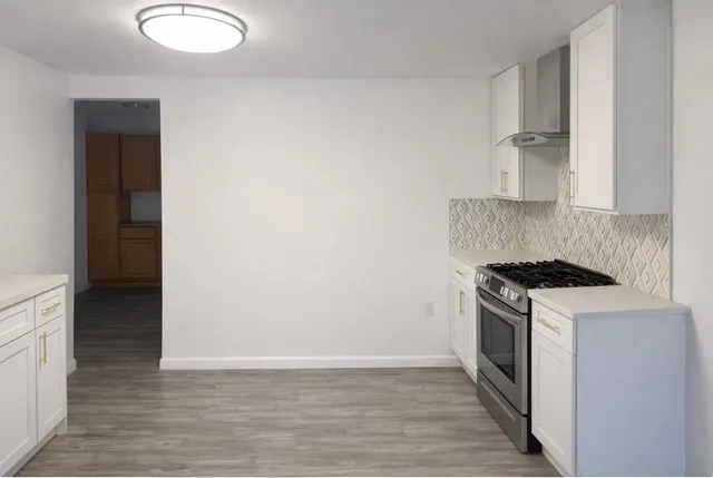 a kitchen with a stove cabinets and wooden floor