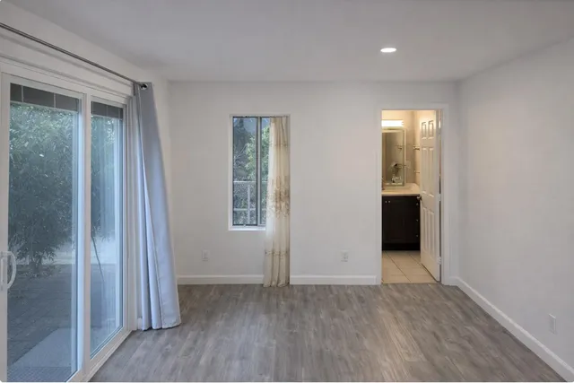 an empty room with wooden floor and a bathroom